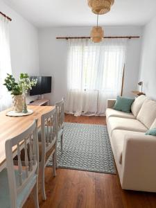 una sala de estar con un sofá y una mesa en Apartamento a Un Paso de la Playa de Tapia, en Tapia de Casariego
