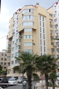 ein hohes Gebäude mit Palmen davor in der Unterkunft Aquapark Apartment in Baku