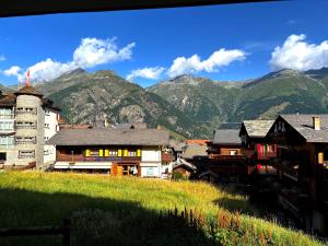 un villaggio in montagna con montagne sullo sfondo di Bright apartment close to center a Grächen