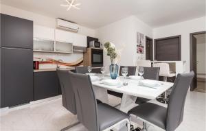 a kitchen and dining room with a white table and chairs at Gorgeous Home In Rukavac With Kitchen in Rukavac
