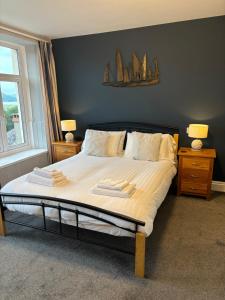 a bedroom with a large bed with two towels on it at Bryn Melyn Apartments in Barmouth