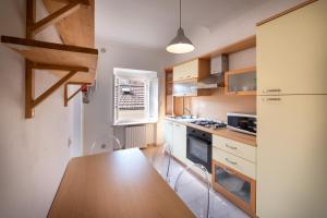 a kitchen with a wooden table and a refrigerator at La Maison Blanche - Fano Historical Center in Fano