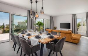 a dining room with a table and chairs and a couch at Awesome Home In Vodice in Vodice