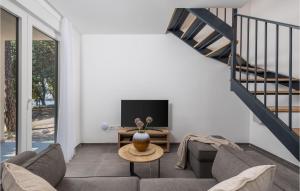 a living room with a couch and a tv at Stunning Home In Kraljevica With Wifi in Kraljevica