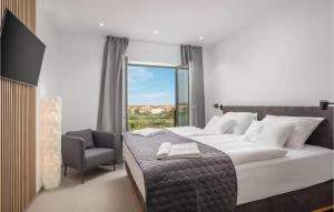 a bedroom with a bed and a chair and a window at Awesome Home In Vodice in Vodice +51 photos