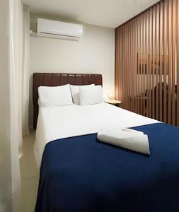 a bedroom with a large bed with a blue blanket at NOVO Skylux 1109 Imponente com Piscina Aquecida WIFI in Rio de Janeiro +42 photos