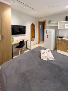 a bedroom with a bed and a desk and a refrigerator at Studio Mauá 705 in Rio de Janeiro