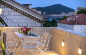 a table and chairs on a balcony with a table and flowers at Villa Mediteran in Dubrovnik