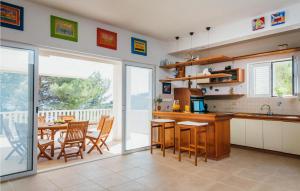 a kitchen and dining room with a table and chairs at Villa Aqua in Vrbanj