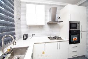Una cocina con gabinetes blancos y un fregadero. en Chanan Court Apartment, en Accra 4 fotos más