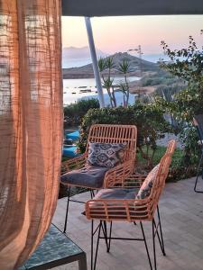 a patio with two chairs and a view of the ocean at CasaEole in El Haouaria