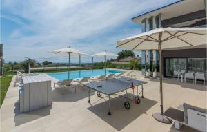 un patio avec une table et des parasols à côté d'une piscine dans l'établissement Villa Gabrijela Kastelir, à Kaštelir
