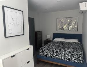 a bedroom with a bed and a painting on the wall at 925 Rentals in Hamilton