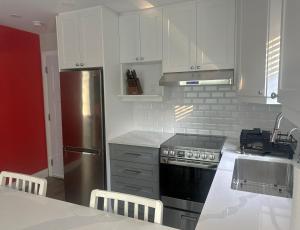 a kitchen with white cabinets and a stainless steel refrigerator at 925 Rentals in Hamilton
