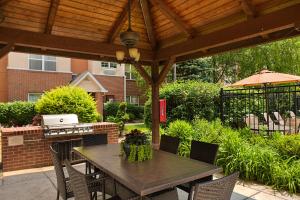 a patio with a table and chairs under a wooden roof at Residence Inn Chicago O'Hare in Rosemont