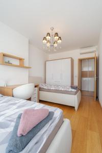 Un dormitorio con dos camas y una lámpara de araña. en Downtown apartment in the heart of the new city center, 4 persons, parking, en Bratislava