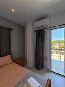 a bedroom with a bed and a large window at The Darling Guesthouse in Himare