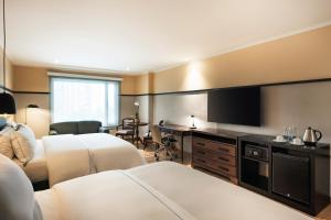 a hotel room with a bed and a television at Hotel Poblado Plaza in Medellín +70 photos