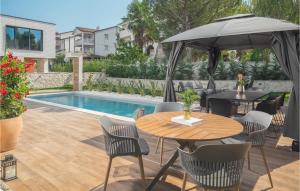 a patio with a table and umbrella next to a pool at Villa Golden Shine in Poreč +45 photos