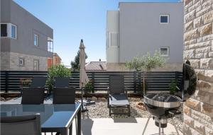 a patio with chairs and a table and a grill at Villa Valencan 3 in Mednjan