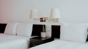 a bedroom with two beds with white pillows and a lamp at Hotel San Felipe in Oaxaca City