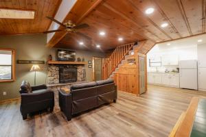 een woonkamer met een plafondventilator en een open haard bij Kelley's Kabin #290 in Big Bear Lake +10 foto's