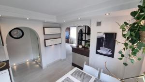 a room with white walls and a clock on the wall at Biały Apartament in Pisz