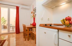 a kitchen with a table with a bowl of fruit at Gorgeous Apartment In Baska Voda in Baška Voda