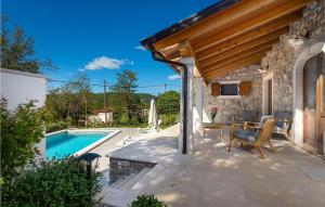 a patio with a table and chairs next to a pool at Gorgeous Home In Plomin With Kitchen in Plomin +36 photos