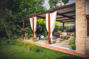 a pergola with a couch and chairs in a yard at PranaVita, B&B Naturale in Pesaro