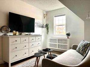 a living room with a white dresser with a flat screen tv at Top Floor Mountain View Escape in Canmore