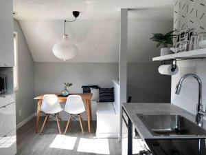 a kitchen with a wooden table and white chairs at Top Floor Mountain View Escape in Canmore