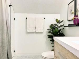 a white bathroom with a toilet and a towel rack at Top Floor Mountain View Escape in Canmore +37 photos