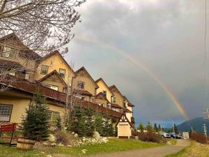 a rainbow in the sky over a house at Top Floor Mountain View Escape in Canmore