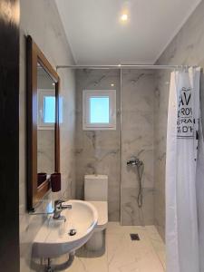 a bathroom with a shower and a sink and a toilet at The Darling Guesthouse in Himare