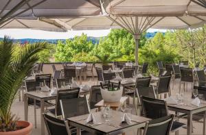 ein Restaurant mit Tischen, Stühlen und Sonnenschirmen in der Unterkunft Hotel Sonnengut Wellness - Therme - Spa in Bad Birnbach