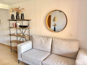a living room with a couch and a mirror at Sun and Golf Holidays at Mar Menor Golf Resort in Torre-Pacheco