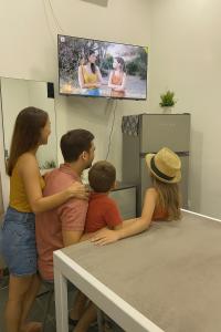 a group of people sitting at a table watching a tv at Lungo il mare in Pozzuoli +4 photos