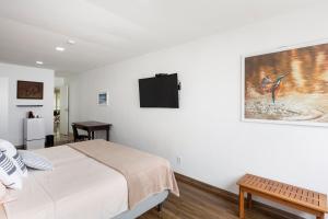 a bedroom with a bed and a picture on the wall at Cobertura com linda vista da praia do Pêpe in Búzios