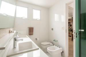 a white bathroom with a sink and a toilet at Cobertura com linda vista da praia do Pêpe in Búzios +37 photos