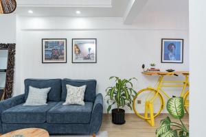 a living room with a blue couch and a yellow bike at Marina Bay Unique 1 Bedroom in Westland's Off Rhapta Road-Zawi in Nairobi