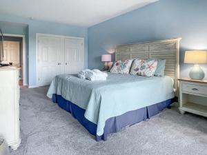 une chambre avec un grand lit aux murs bleus dans l'établissement 1824 Beachside Tennis at The Sea Pines Resort, à Île de Hilton-Head