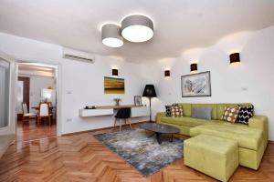 salon z zieloną kanapą i stołem w obiekcie Apartments in Porec - Istrien 40311 w Poreču