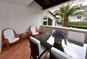 patio ze stołem, krzesłami i palmą w obiekcie Apartments in Porec - Istrien 40311 w Poreču