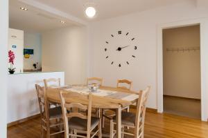 a dining room with a table and a clock on the wall at Nakos Homes Luxury Apartment-Acropolis Area in Athens