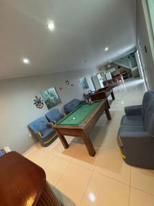 サリノポリスにあるCasa Praia do Atalaiaのリビングルーム(ビリヤード台、椅子付)
