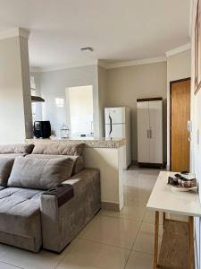 a living room with a couch and a kitchen at Residencial Algarve in Patos de Minas