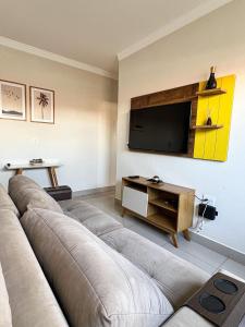 a living room with a couch and a flat screen tv at Residencial Algarve in Patos de Minas