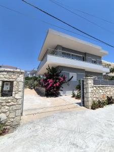a large white house with flowers in front of it at The Darling Guesthouse in Himare