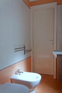 een badkamer met een witte wastafel en een deur bij Casa Caporosso Giusti in Maruggio
